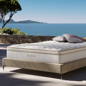 A Saatva mattress displayed outside near the ocean.